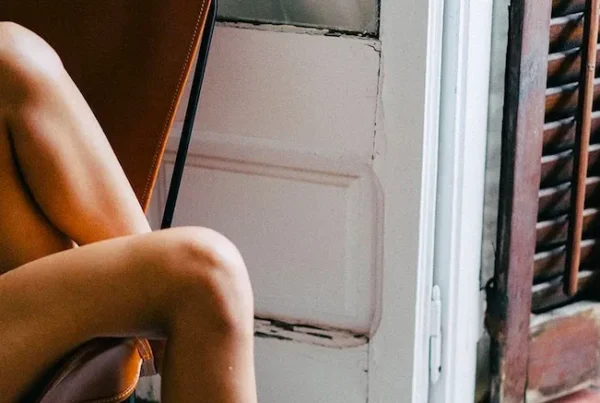 A confident woman in elegant underwear reclining gracefully on a chair, embodying self-love and body positivity.